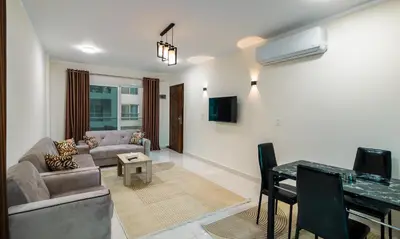 a living room with a couch and a table at Luxury City Center One-Bedroom Suite by Peaks in Hurghada