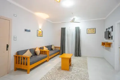 a living room with a couch and a tv at Eldeak Hotel Apartments in Luxor