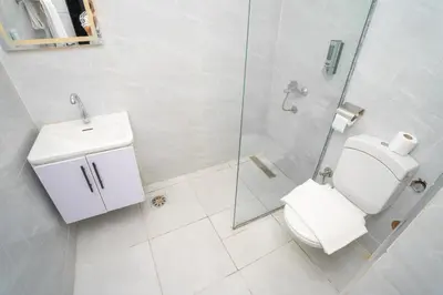 a white bathroom with a toilet and a shower at Eldeak Hotel Apartments in Luxor