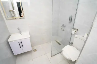 a bathroom with a toilet and a glass shower at Eldeak Hotel Apartments in Luxor