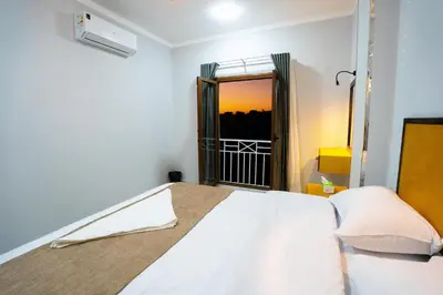 a bedroom with a white bed and a mirror at Eldeak Hotel Apartments in Luxor