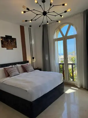 a bedroom with a large bed with a large window at Exklusives Apartment mit Dachterrasse und Meerblick in Hurghada
