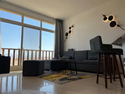a living room with a couch and a table at Exklusives Apartment mit Dachterrasse und Meerblick in Hurghada