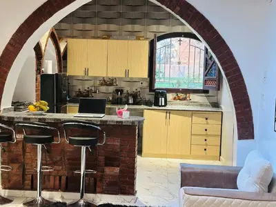 an archway in a kitchen with a laptop on a counter at Villa Farida Palace in Al Aqālitah