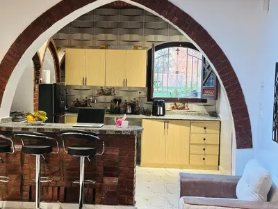 an archway in a kitchen with a laptop on a counter at Villa Farida Palace in Al Aqālitah