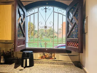a kitchen window with a view of a yard at Villa Farida Palace in Al Aqālitah