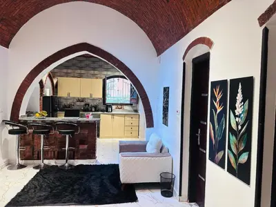 a kitchen with an archway and a table and chairs at Villa Farida Palace in Al Aqālitah