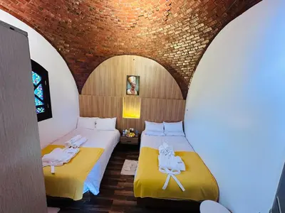 two beds in a room with a brick wall at Villa Farida Palace in Al Aqālitah