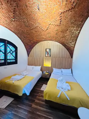 two beds in a room with a brick wall at Villa Farida Palace in Al Aqālitah