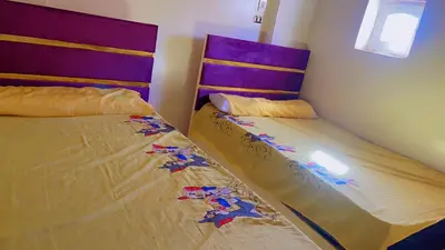 two beds sitting next to each other in a bedroom at the little house in Aswan