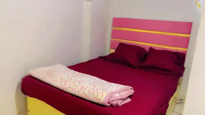 a bed with a pink blanket on top of it at the little house in Aswan
