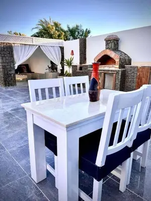 a white table with two chairs and a vase on it at Touristic Center in Hurghada