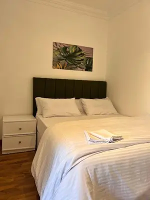 a bedroom with a white bed with a green headboard at Touristic Center in Hurghada