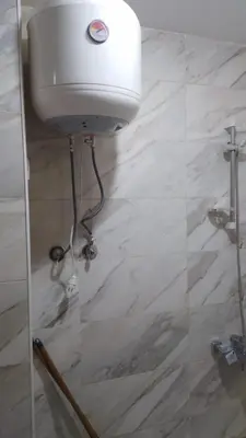 a shower head in a bathroom with a marble floor at Tiba Golden Resort in Hurghada