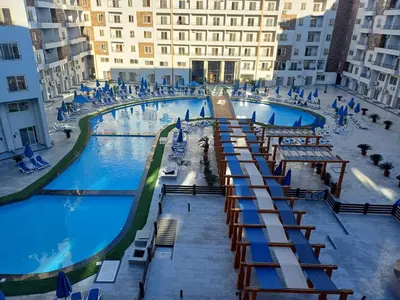 a large pool with tables and chairs in a building at Tiba Golden Resort in Hurghada