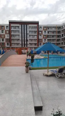a pool with a chair and an umbrella and a building at Tiba Golden Resort in Hurghada