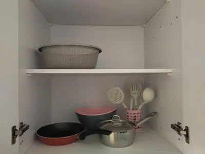 a kitchen with bowls and utensils on a shelf at Tiba Golden Resort apartment 167 in Hurghada