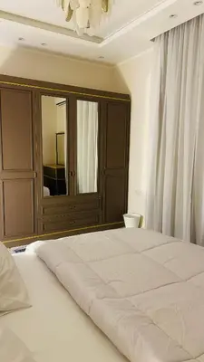 a bedroom with a large bed and a large mirror at Hasnaa apartment in Hurghada