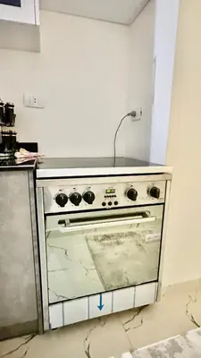 a kitchen with a stove in a room at Hasnaa apartment in Hurghada