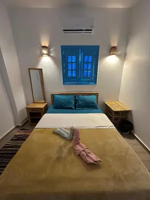 a bedroom with a bed and a blue window at Palm Guest House in Aswan