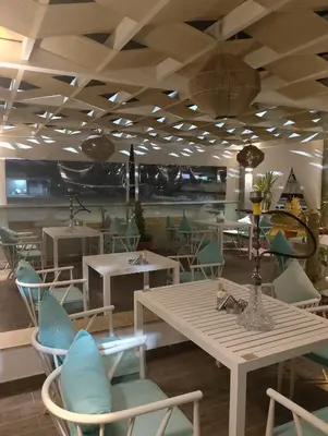 a restaurant with white tables and blue chairs at Fanadir bay in Hurghada
