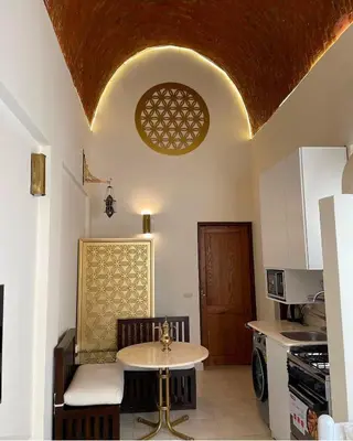 a kitchen with a table and a small table in a room at Serene Apartment Makadi Heights in Hurghada