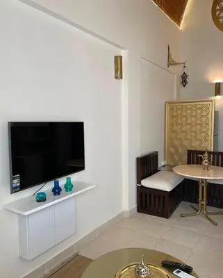 a living room with a large flat screen tv on a wall at Serene Apartment Makadi Heights in Hurghada