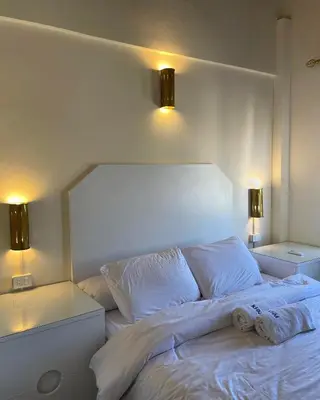a white bed with two lights on top of it at Serene Apartment Makadi Heights in Hurghada