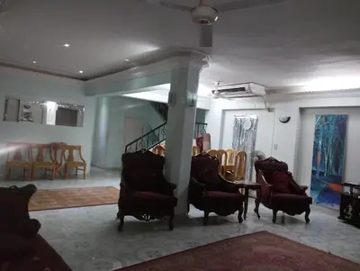 a living room with chairs and a table and a staircase at فيلا عبدالله محروس in Aswan