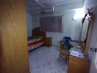 a room with a bedroom with a bed and a chair at فيلا عبدالله محروس in Aswan