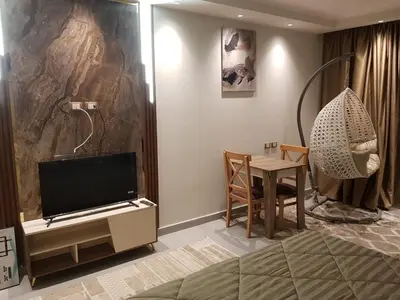 a room with a bedroom with a table and a television at Scandic Resort Hurghada in Hurghada