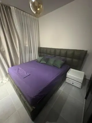 a bedroom with a bed with purple sheets and green pillows at luxury apartment Makadi heights phase 2 in Hurghada