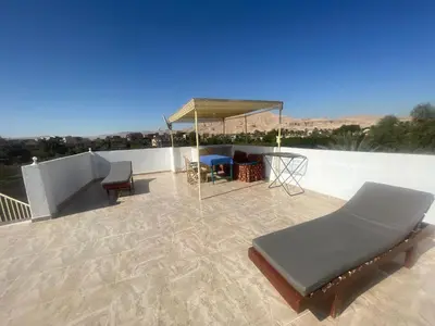 a patio with a table and chairs on a roof at Tonys Flat in Al Aqālitah