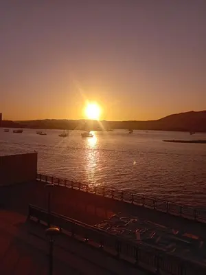 a sunset over a body of water with boats at Hamdy's Felouque in Aswan