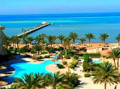 a view of a resort with a pool and the ocean at Home always in Hurghada