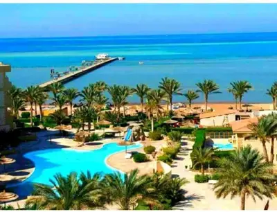 a view of a resort with a pool and the ocean at Home always in Hurghada