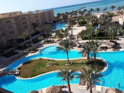 an aerial view of a resort pool with palm trees at Home always in Hurghada