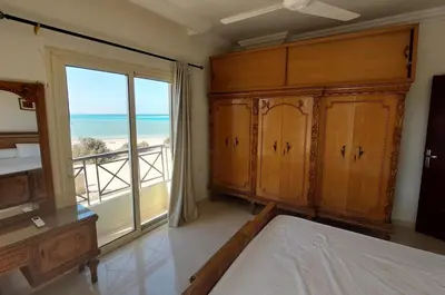 a bedroom with a bed and a large window with the ocean at Hurghada Concierge at Casablanca Resort in Hurghada