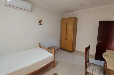 a bedroom with a bed and a cabinet and a chair at Hurghada Concierge at Casablanca Resort in Hurghada
