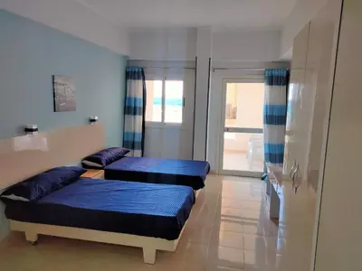 two beds in a room with blue pillows at Aquarium Seaview accomodations in Hurghada