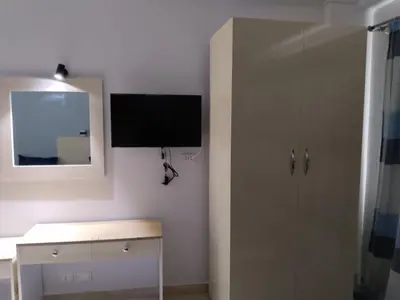 a bathroom with a tv on the wall next to a cabinet at Aquarium Seaview accomodations in Hurghada