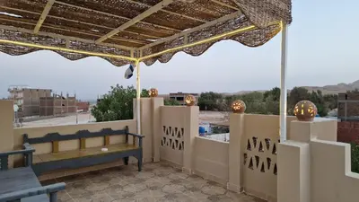 a patio with a bench and an umbrella at House Mountain in ‘Ezbet Abu Ḥabashi
