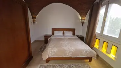 a bedroom with a bed and a large window at House Mountain in ‘Ezbet Abu Ḥabashi
