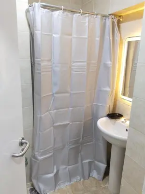 a white shower curtain in a bathroom with a sink at Aquarium Seaview accomodations in Hurghada