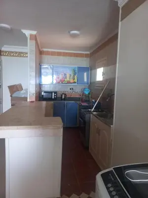 a kitchen with blue cabinets and a counter top at شقة فندقية على البحر منطقة القيادات 2 in Hurghada