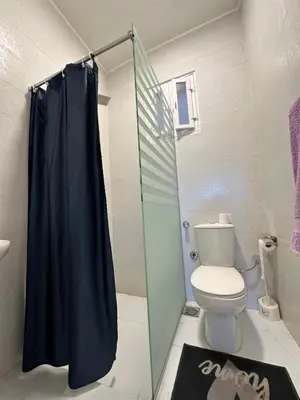 a bathroom with a toilet and a glass shower at Tuya House Luxor in Luxor
