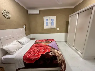 a bedroom with a bed with a red rose blanket at Tuya House Luxor in Luxor