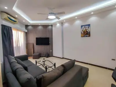 a living room with a couch and a flat screen tv at Sea view one bedroom apartment in Hurghada Dreams in Hurghada