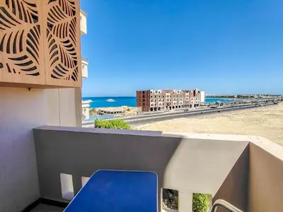a blue chair on a balcony with a view of the beach at Sea view one bedroom apartment in Hurghada Dreams in Hurghada