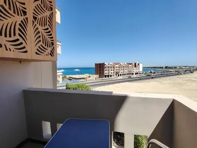 a view of the beach from the balcony of a building at Sea view one bedroom apartment in Hurghada Dreams in Hurghada